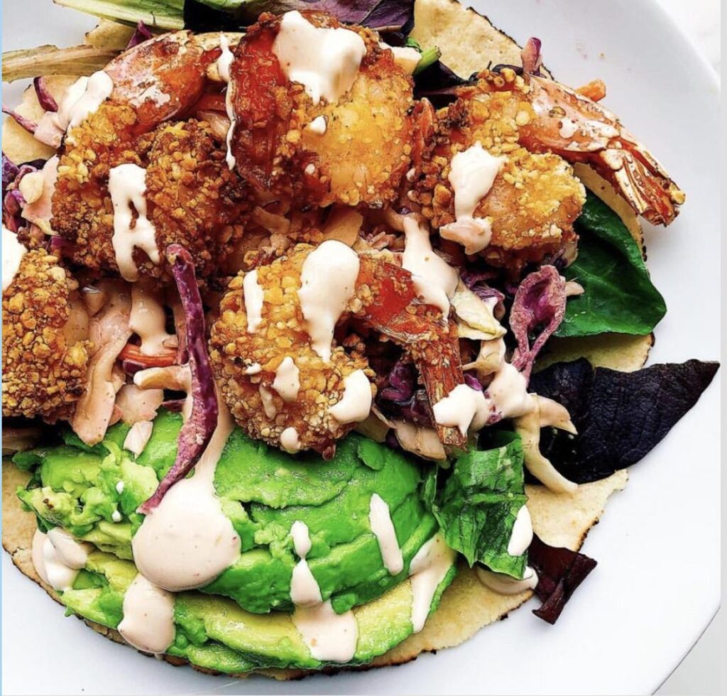 Air fried shrimp taco with avocado and drizzled crema on top
