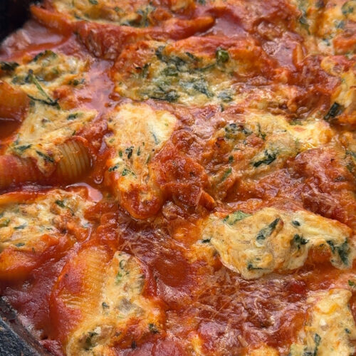cooked pasta shells in a cast iron stuffed with butternut squash, ricotta and spinach and topped with more red sauce sauce