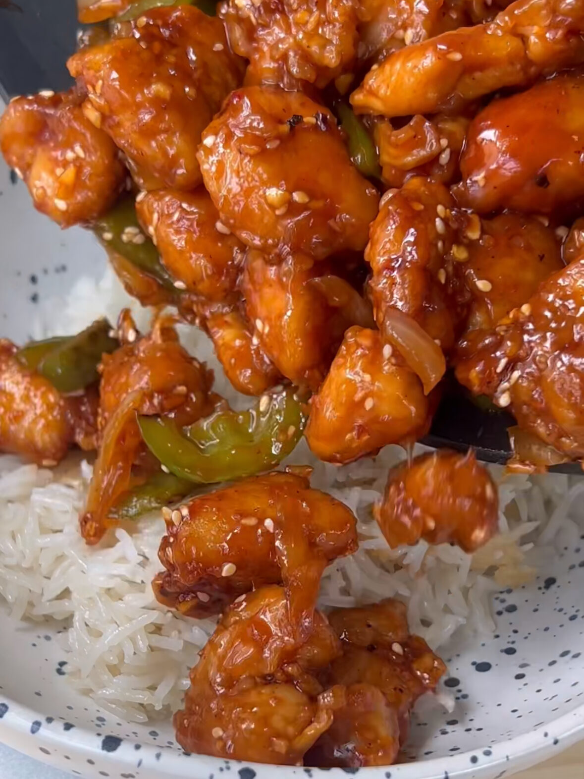 Sesame chicken being poured over coconut rice!