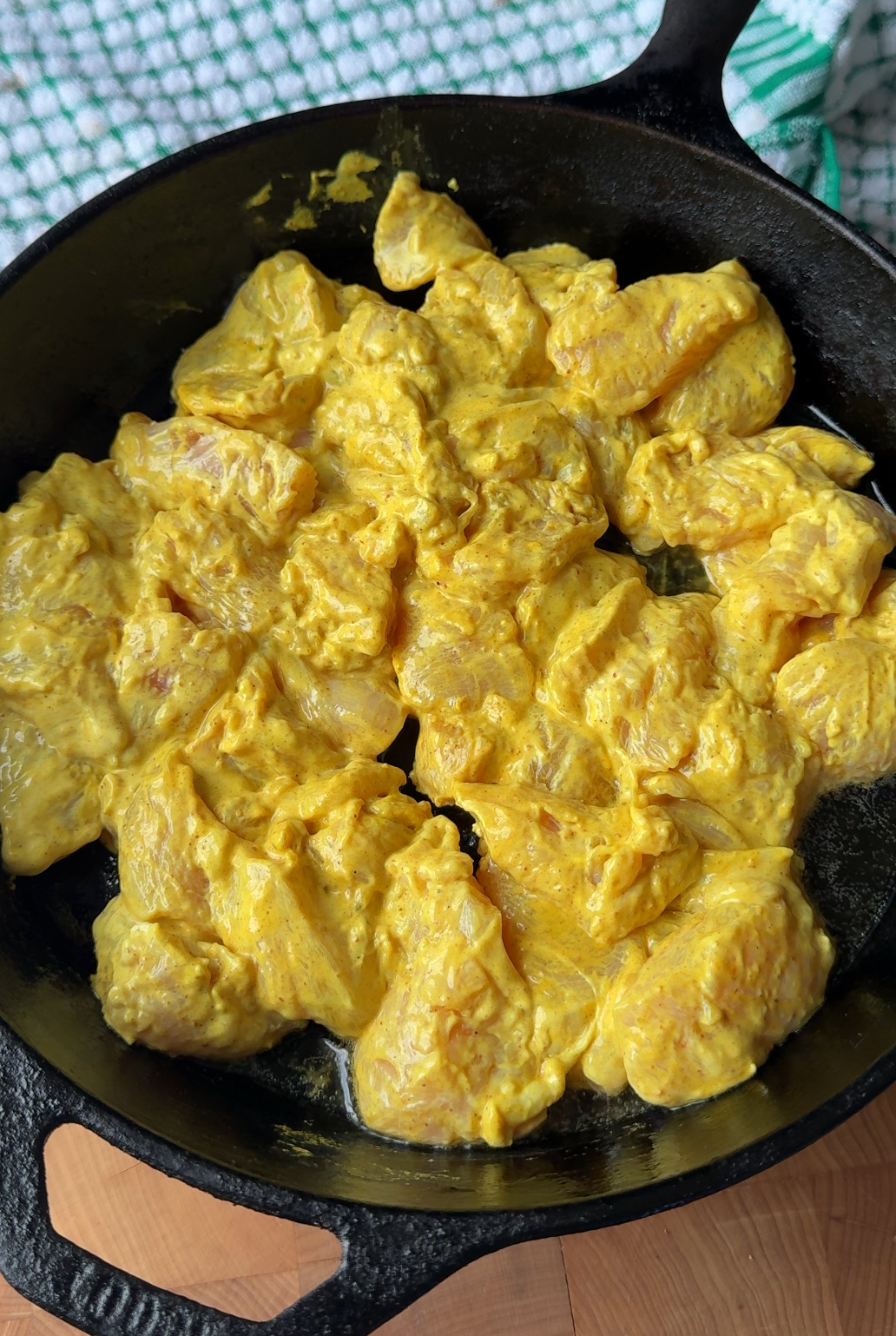 curry marinated chicken in a cast iron skillet