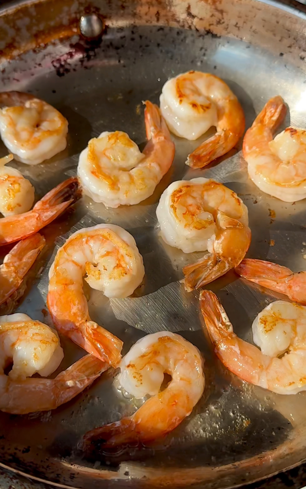 shrimp being sautéed eed in a stainless steel pan