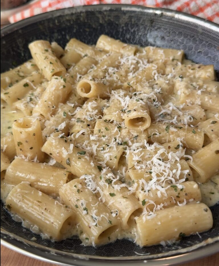 creamy pasta in a pan with Parmesan on top