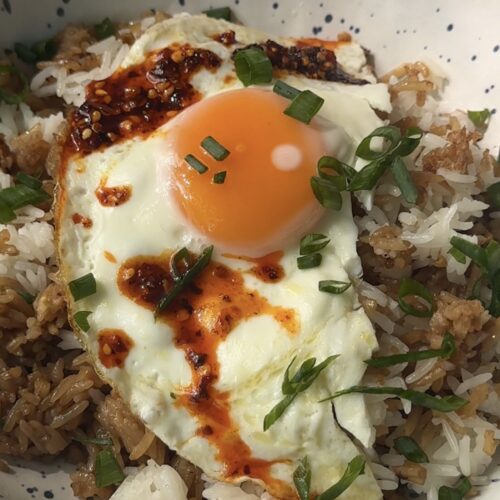 fried egg over leftover rice topped with chili crunch and scallions